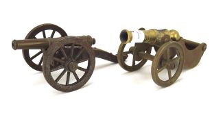 Two brass tabletop firing cannons, mounted on artillery wheels,
