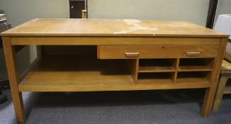 A mid-20th century beech effect work table, with single drawer, open racks and undertier,