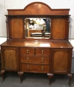 An Edwardian mahogany sideboard with mirror, the base fitted with drawers flanked by panelled doors,
