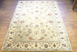 A large 20th century beige floor rug, decorated with floral motifs,