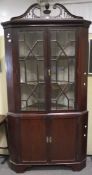 A Victorian mahogany corner cupboard, in two sections, the top being glazed,