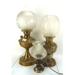 Three brass oil lamps, two large and another smaller example, with glass shades,