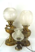 Three brass oil lamps, two large and another smaller example, with glass shades,