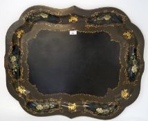 A Victorian papier mache tray, of shaped form, hand painted with cartouches containing flowers,