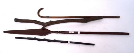 Three wooden walking sticks and a wooden spear, two sticks with silver tops or collars,