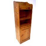 A 20th century pine unit, with single drawer over two shelves and a single door cupboard,