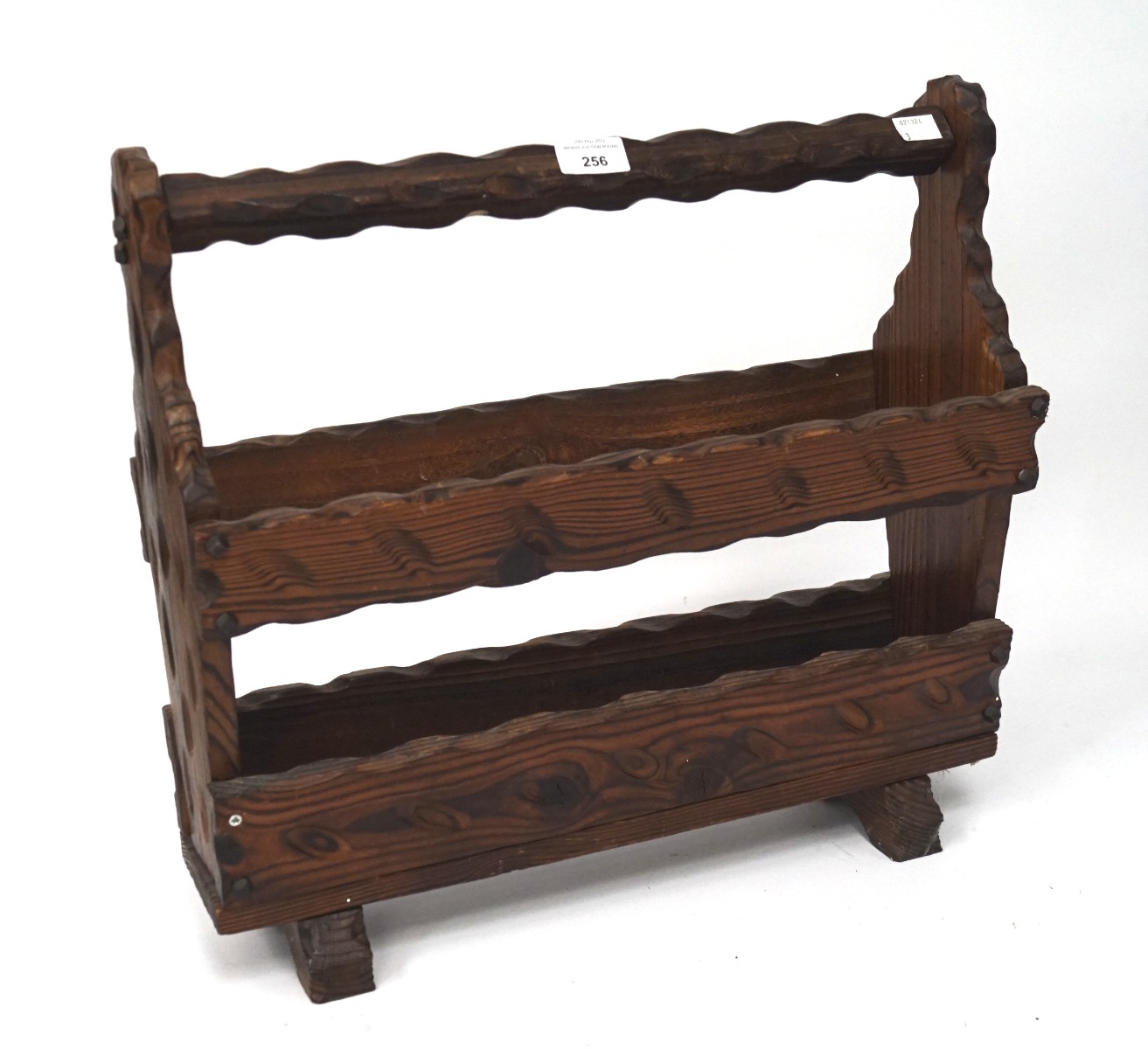 A 20th century carved wooden magazine rack, with textured decoration,