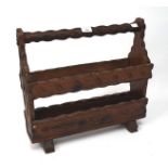 A 20th century carved wooden magazine rack, with textured decoration,