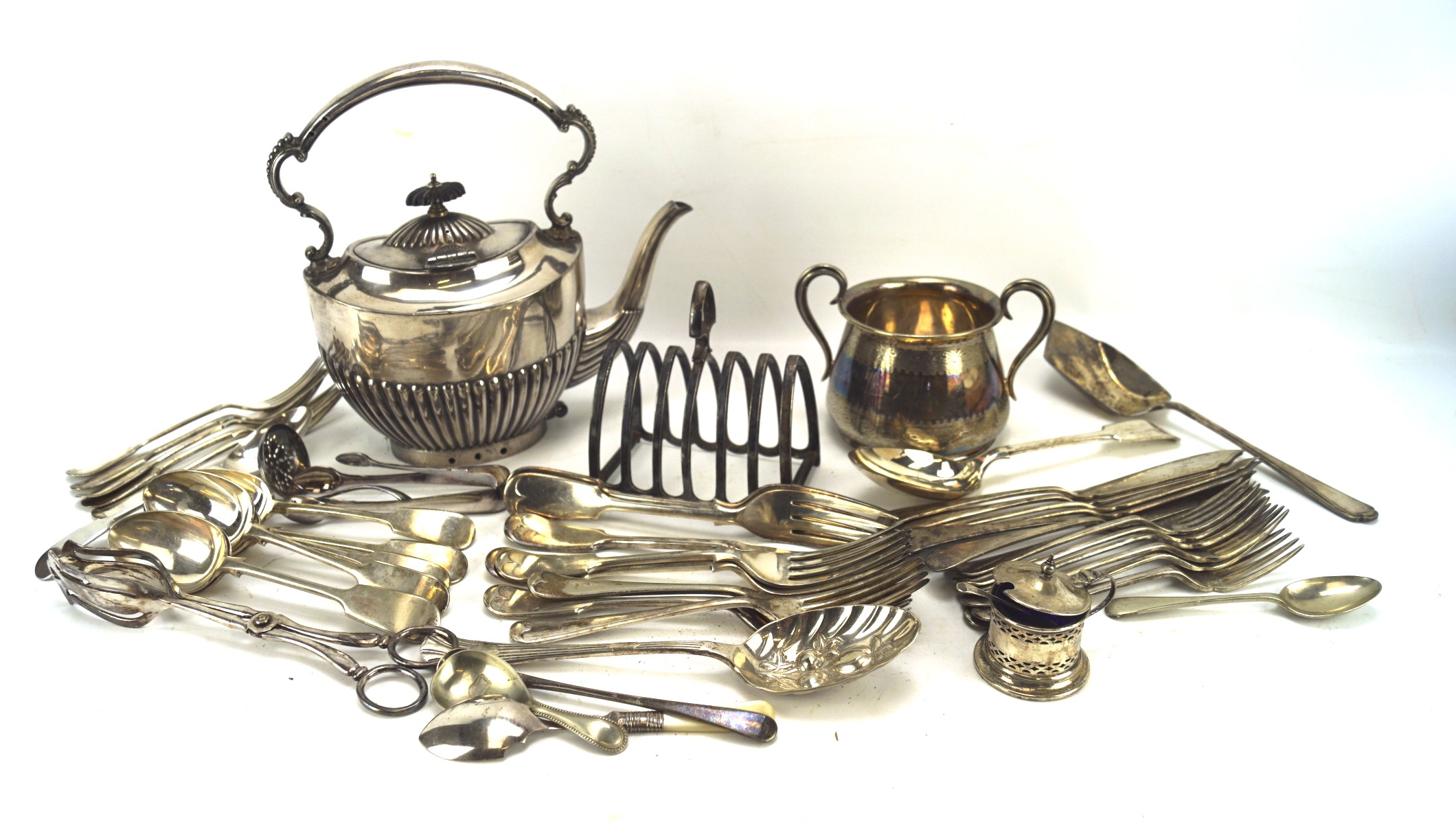 An assortment of silver plate, including flatware, six slice toast rack, Edwardian tea pot,