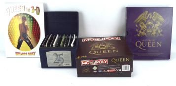 An assortment of Queen memorabilia, including a 'Queen in 3-D' volume by Brian May,