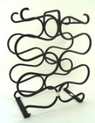 A 20th century cast metal wine rack of serpentine form,