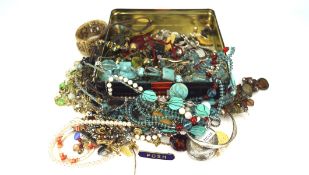 An assortment of costume jewellery, including a locket, bracelets, necklaces, brooches,