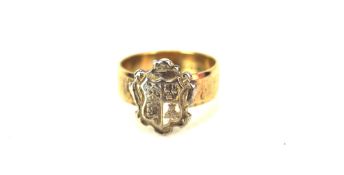 A 9ct gold child's ring, featuring a white metal coat of arms, 2.