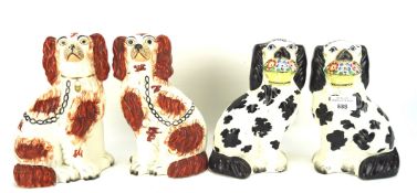 Two pairs of Staffordshire pottery spaniels, one pair in red, the other in black,