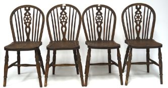 Four matching elm seated wheelback chairs, raised upon turned supports,