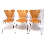 A set of three kitchen chairs, the shaped wooden frames mounted on chrome supports,