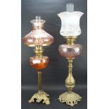 Two early 20th century oil lamps, both with cast metal bases,