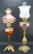 Two early 20th century oil lamps, both with cast metal bases,