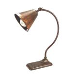 A vintage copper desk lamp with funnel shade,