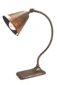 A vintage copper desk lamp with funnel shade,