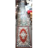 Seven small carpets/rugs, of varying designs and colours,