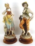 A large pair of 20th century figures, depicting a male and female in traditional dress,