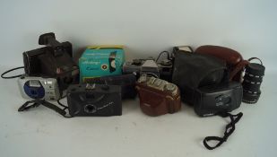 An assortment of cameras and lenses, including a Praktica LB, Optomax no.