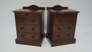 A pair of 20th century stained wooden bedside chests of drawers,