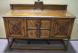 An oak galleried sideboard with two drawers flanked by two cupboards on barley twist supports and