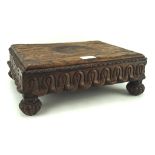 An oak footstool of rectangular form with carved apron and raised on fluted bun supports, L35.