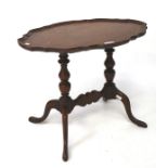 An early/mid-20th century mahogany occasional table, of oval form with pie crust border,