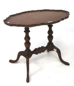 An early/mid-20th century mahogany occasional table, of oval form with pie crust border,