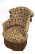 An Edwardian upholstered button back tub chair, upholstered in floral fabric suspending fringing,