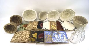 An assortment of ceramic tiles and jelly moulds,