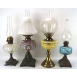Four oil lamps, each having a glass reservoir and glass funnel, two with original glass shades,
