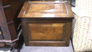 A late 19th/early 20th century oak chest, with slanted hinged lid and panels to the top and sides,