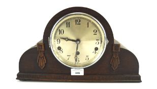 An early 20th century oak cased mantel clock, the silvered dial with Arabic numerals denoting hours,
