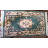 A 20th century rug, featuring a cream floral medallion to the centre and matching border,