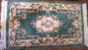 A 20th century rug, featuring a cream floral medallion to the centre and matching border,