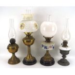 Four early/mid 20th century oil lamps, one with glass reservoir, two with glass shades,