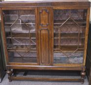 An early 20th century display cabinet, featuring two astragal glazed doors,