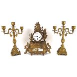 An early 20th century mantel clock and a pair of candlesticks,