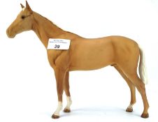 A Beswick horse, in light brown with a white mane and tail,
