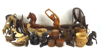 An assortment of treen, including carved animals and figures, turned wooden pots, walking sticks,