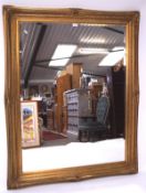 A large bevelled edge wall mirror, of rectangular form, with gilt frame,