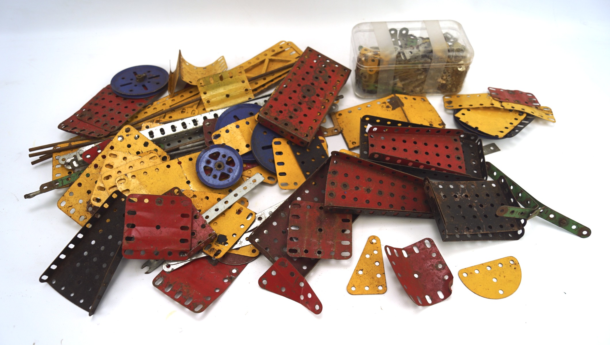 A large collection of Meccano, the pieces of various sizes, designs and colours,