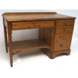 A 20th century pine desk, with three drawers to the right side and turned supports,