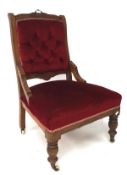 An early 20th century button back elbow chair, upholstered in red velvet,