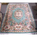 A mustard ground floor rug, machine made, decorated with black and rust coloured patterns,