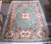 A mustard ground floor rug, machine made, decorated with black and rust coloured patterns,